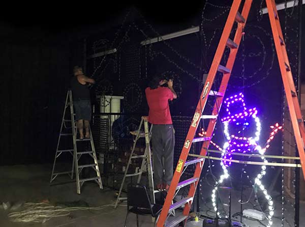 Workers apply pixels to Santa's Toy Shop in Mega Light Show's Custom Built Shop